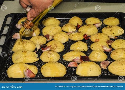 Potatoes With Ridges Garlic And Olive Oil On A Baking Tray Stock