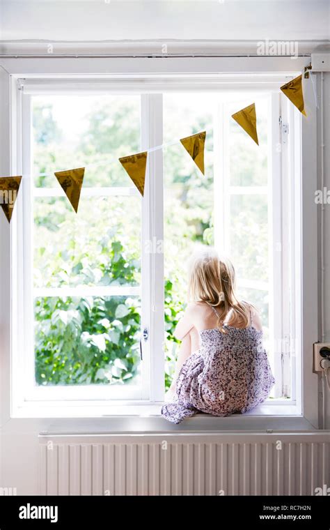 Girl Looking Through Window Stock Photo Alamy