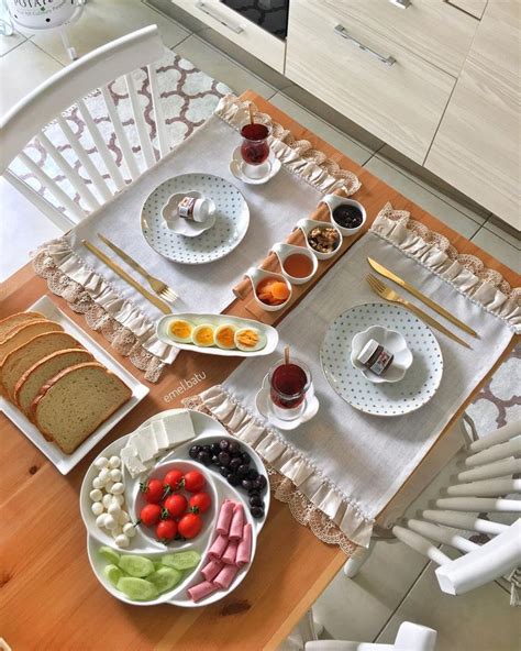 A Wooden Table Topped With White Plates And Bowls Filled With Fruit On