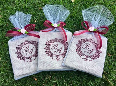 Three Personalized Towels On The Grass With Red Ribbons And Bows Are