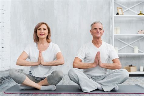 Senior Famille Couple Assis En Posture De Lotus Sur Tapis D Yoga Gris