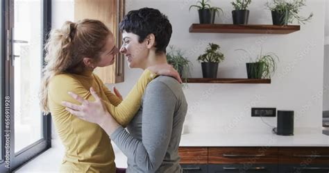 Vidéo Stock Happy caucasian lesbian couple embracing and kissing in sunny kitchen copy space