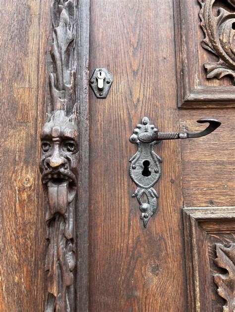 An Old Door Handle With A Face On It