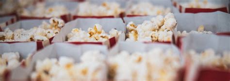 Many Red Bags Filled With Popcorn Sitting Next To Each Other