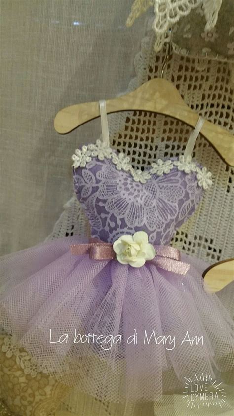 A Doll In A Purple Dress Sitting On A Wooden Chair With Laces And Flowers