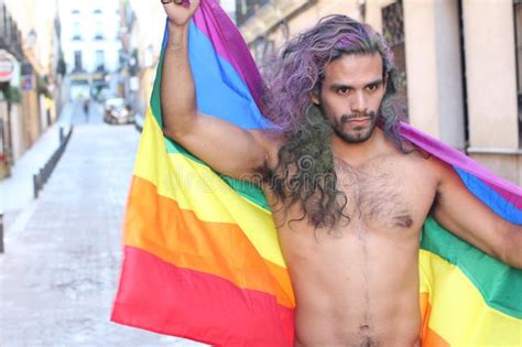 Hombre Gay Resuelto Que Marcha Con La Bandera Del Arco Iris Foto De Archivo Imagen De