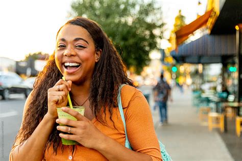 Woman Drinks Green Juice Outside By Stocksy Contributor Jayme