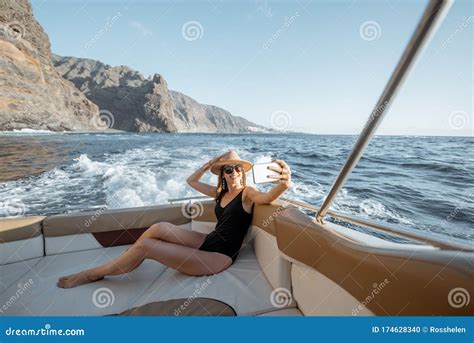 Relaxed Woman Sailing On The Yacht Near The Rocky Coast Stock Photo