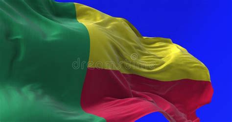 Close Up Of Benin National Flag Waving Isolated On Blue Background