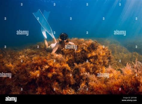 Freediver Girl With White Fins Posing In Underwater On Bottom With