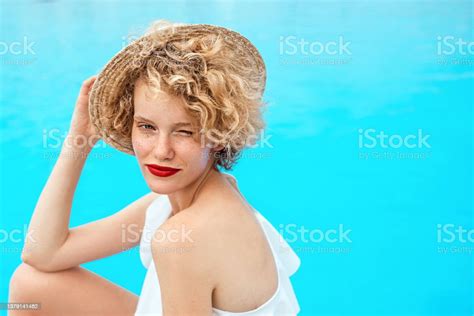 Beautiful Smiling Redhead Woman Portrait Sitting By The Swimming Pool