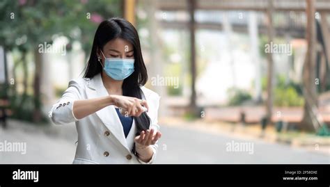 Portrait Of Businesswoman Wearing Mask Sanitizing Hands At Post