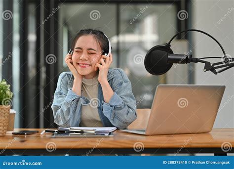 Cheerful Asian Female Radio Host Wearing Headphone Recording Podcast At