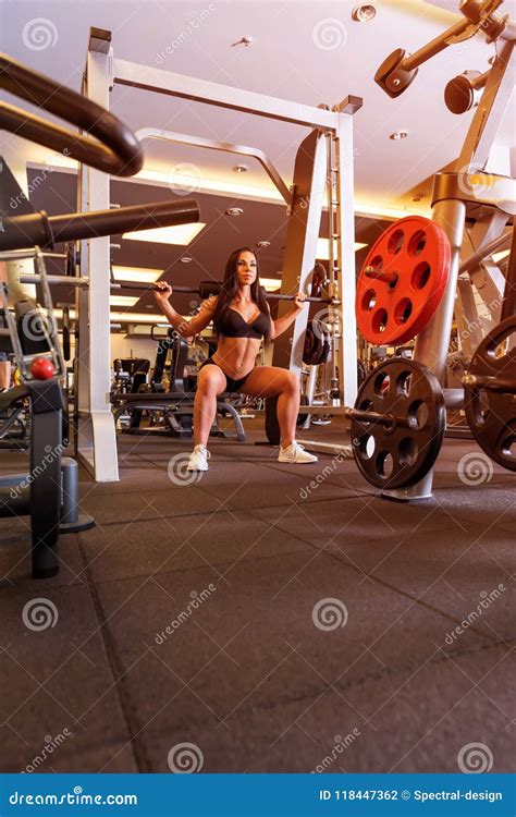 Uma Mulher Que Executa O Levantamento De Peso Exercita No Gym Foto De