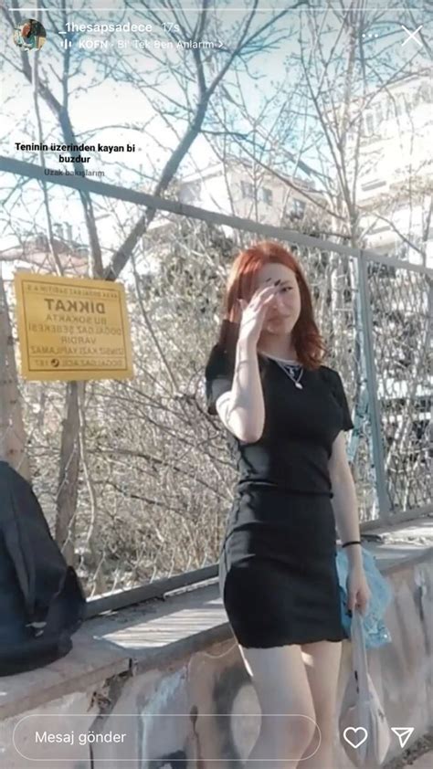 A Woman With Red Hair Is Standing On A Bridge And Talking On Her Cell Phone