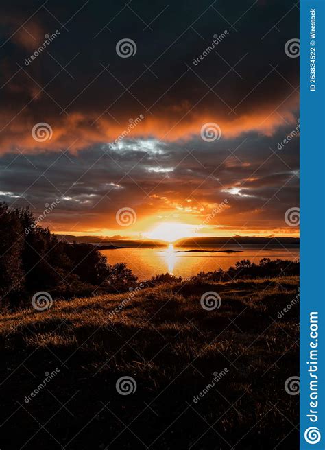 Vertical Shot Of A Bright Orange Sunset Sky Over The Water In Isle Of