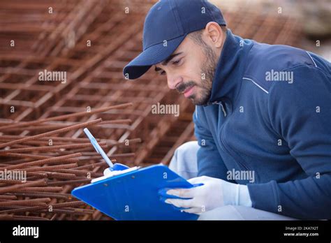 Construction Worker Inspecting Metal Bar Stock Photo Alamy