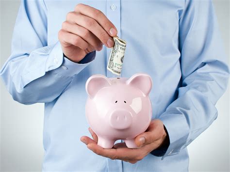 Male Hand Putting Coin Into A Piggy Bank Ars Serwis