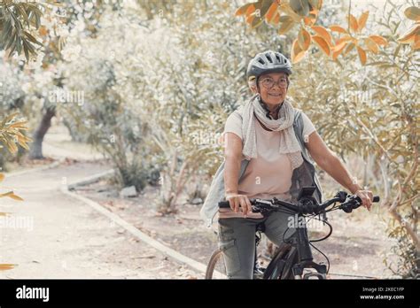 Une vieille femme mature qui fait du vélo et qui profite de la nature