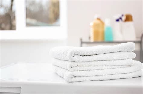 Premium Photo Stack Of Clean Towels On Washing Machine In Laundromat