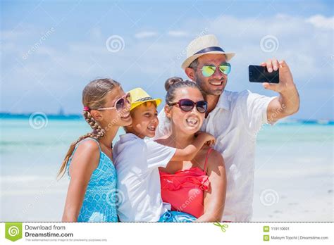 Familia De Cuatro Miembros Que Se Divierte En La Playa Imagen De