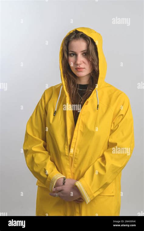 Portrait Of A Girl Dressed In Raincoat Posing With Hood On Her Head And