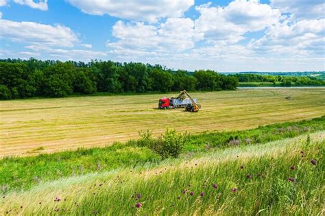 Premium Photo A Ranch Worker Moving Bales Of Hay With A Farm Tractor