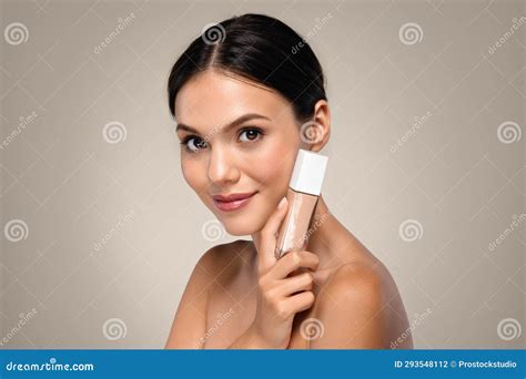 Smiling Young Caucasian Brunette Woman Hold Base Foundation Cream Stock