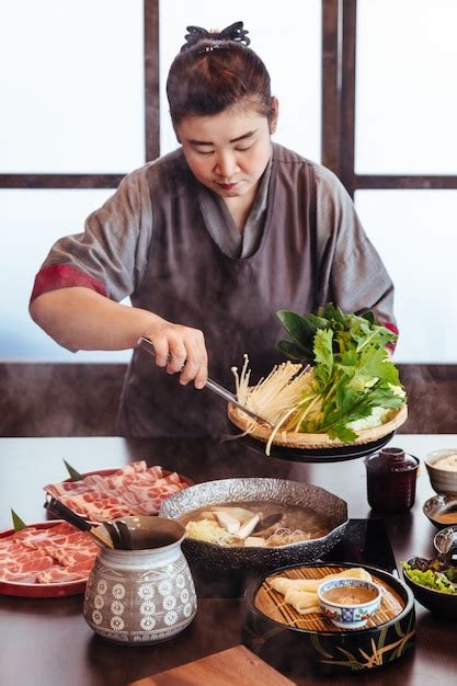Premium Photo A Woman Holding Vegetables Into Hot Pot By Tongs With Wagyu A5 Beef And Sliced