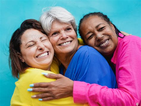 Happy Senior Multiracial Women Having Fun Hugging Each Other Outdoor