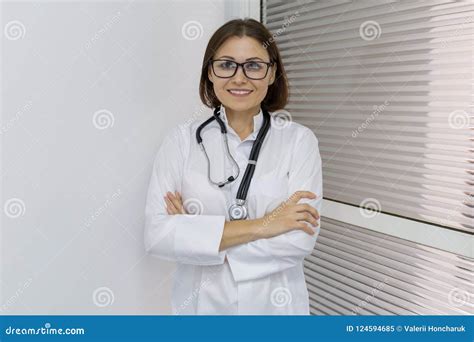 Portrait Of Female Doctor Standing Arms Crossed In Hospital Stock Image