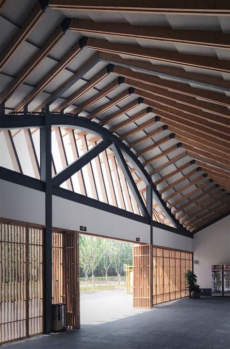 The Inside Of A Building With Wooden Beams And Windows On Each Side Of