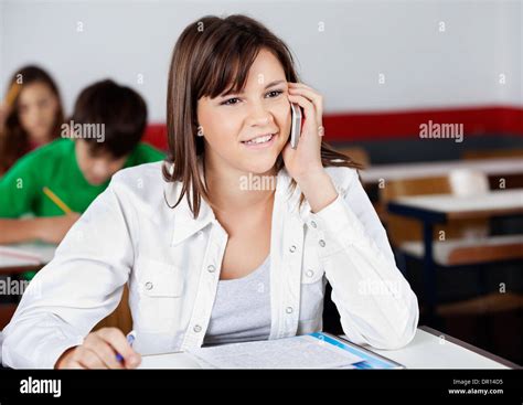 Teenage Girl Answering Mobilephone In Classroom Stock Photo Alamy