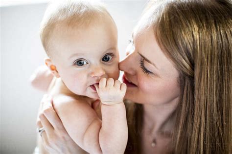 Portrait Of Baby Being Held By Woman Looking At Camera Stock Photo