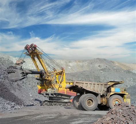 Excavator Loading Iron Ore Into Heavy Dump Trucks On The Opencas Stock