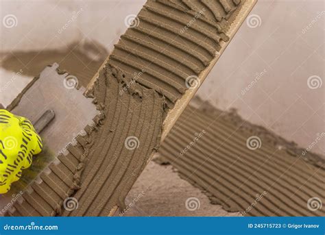 Worker Placing Ceramic Floor Tiles On Adhesive Surface Leveling With