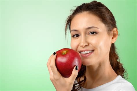 Mujer Sonriente Que Sostiene La Manzana Roja Foto Premium