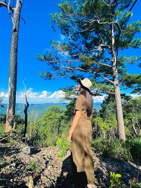 Una niña de pie en el borde del acantilado y mirando las montañas doi