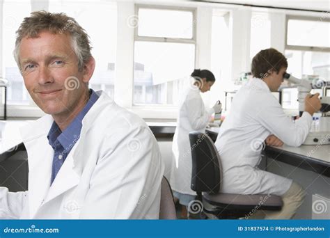 Male Scientist In Ppe Suit Working In Lab While Pouring Solution From