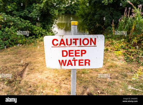 Caution Deep Water Sign By The Side Of A Large Lake River Hazard