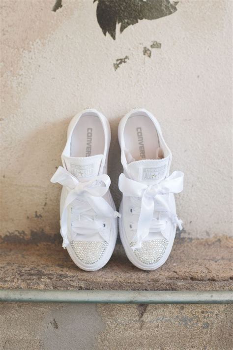 A Pair Of White Tennis Shoes Sitting On Top Of A Ledge