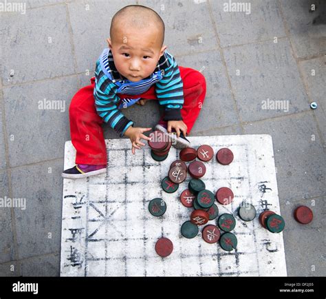 A Boy Playing With Xiangqi Chinese Chess Board And Soldiers Stock