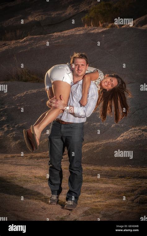 Man Walks Carrying His Girlfriend On His Shoulder Stock Photo Alamy
