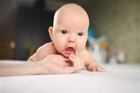 Cute Emotional Funny Newborn Boy Laying On Bed With Mother Hands Baby