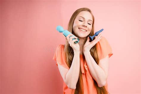 An Attractive Italian Girl With Long Hair Holds Sex Toys In Her Hands Useful For Sex Shops Stock