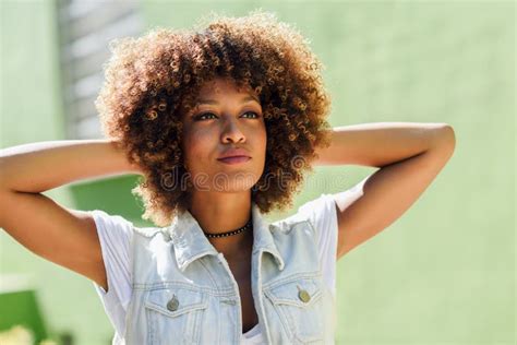 Black Woman Afro Hairstyle Wearing Casual Clothes In Urban Background