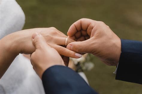 El Novio Pone El Anillo De Bodas En El Dedo Anular De La Novia Foto