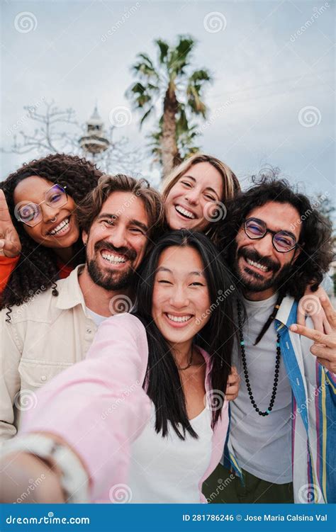 Vertical Portrait Of A Group Of Joyful Young Friends Taking A Selfie