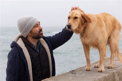 Coup Moyen Homme Avec Chien Au Bord De La Mer Photo Gratuite