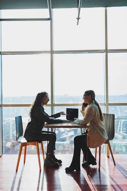 Premium Photo Two Female Coworkers And Colleagues Discussing Working